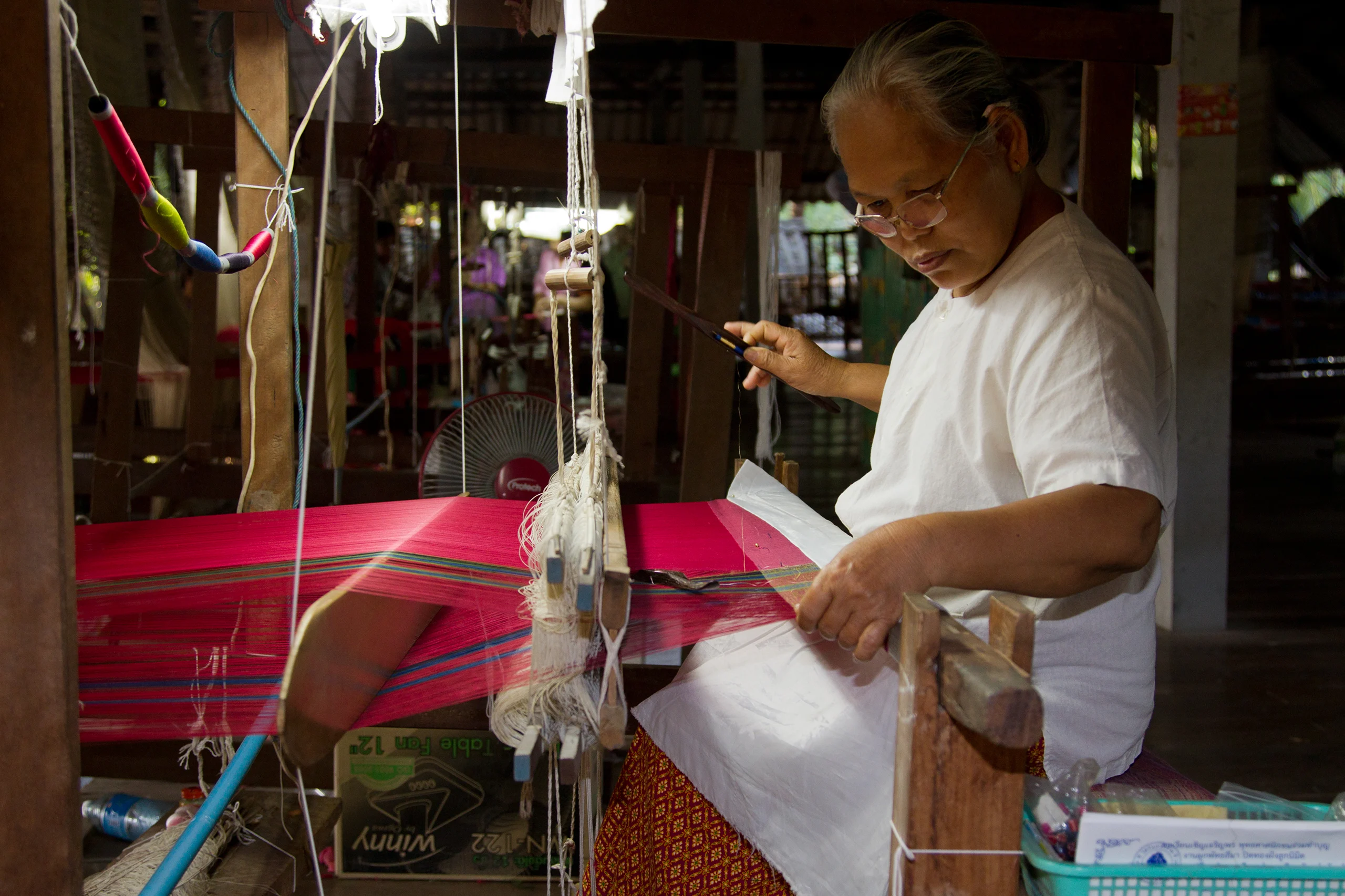 Weaver at a loom in Ban Tha Sawang silk village, Surin