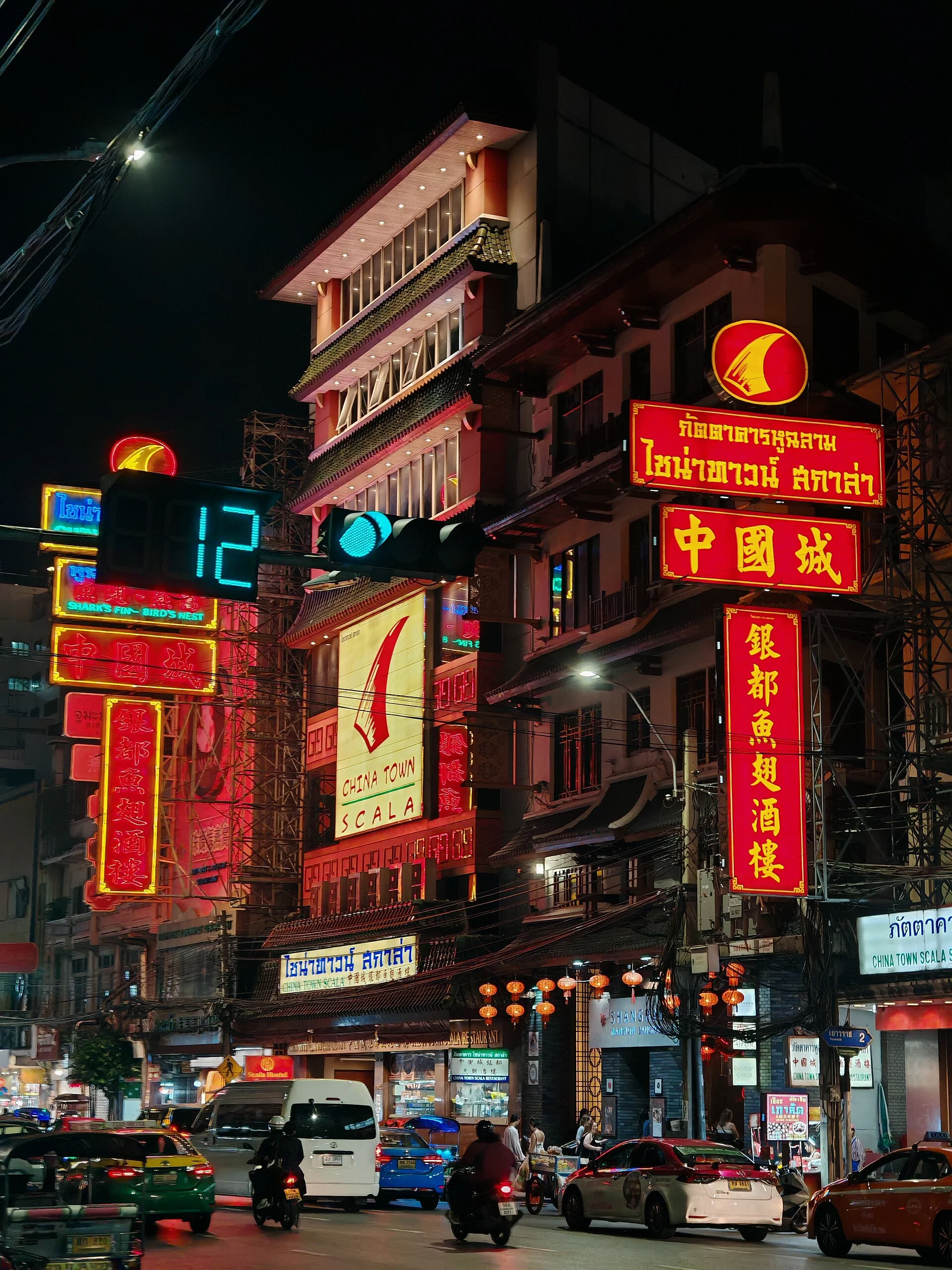 Neon Chinese and Thai signs lighting up Yaowarat Road in Bangkok Chinatown at night