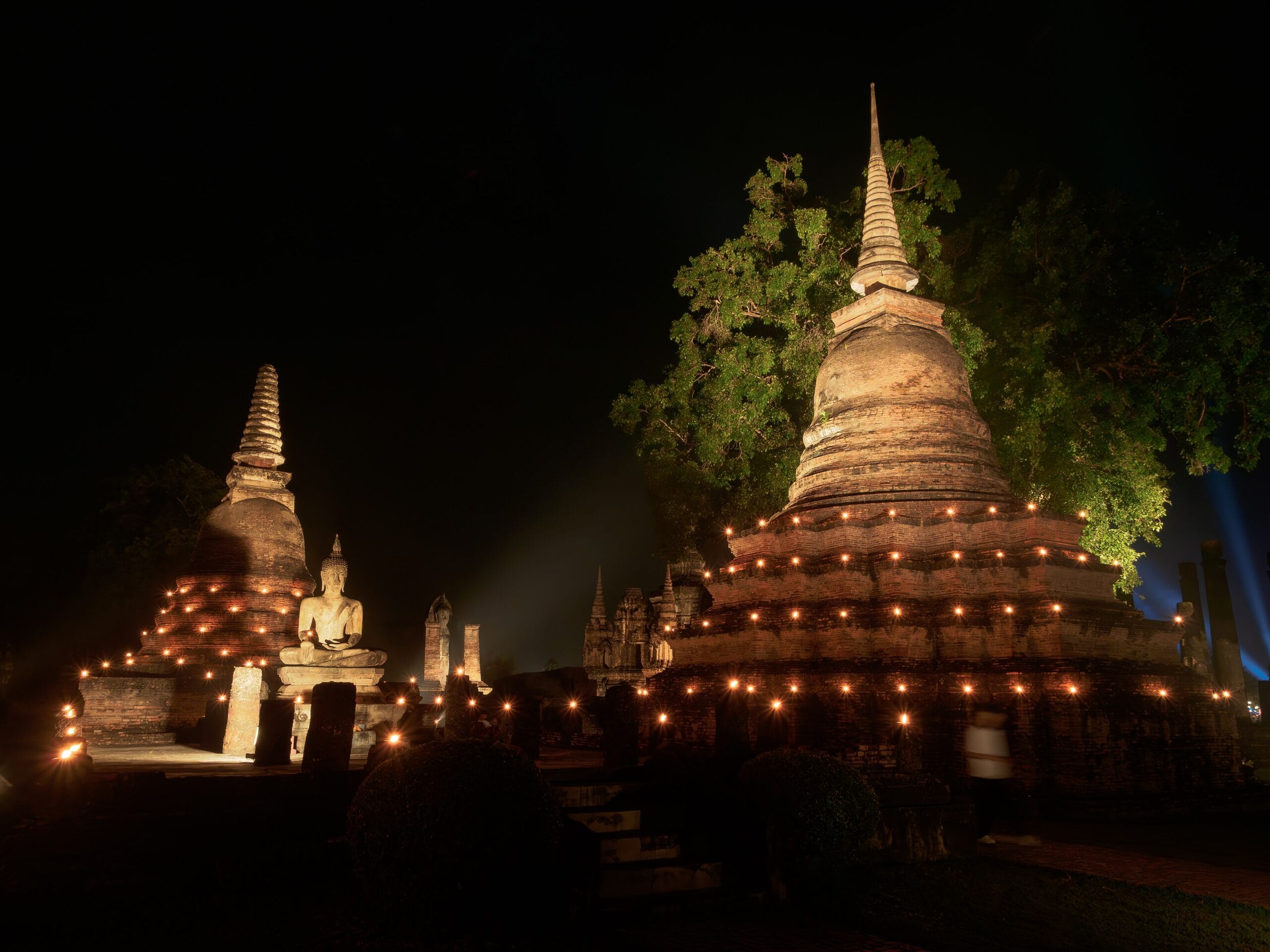 Loy Krathong at Sukhothai Historical Park, lit stupas reflected in the water