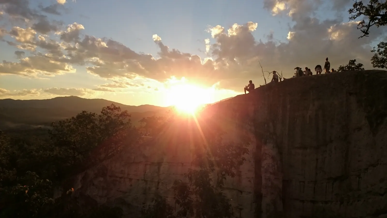 Sunset over Pai Canyon, Mae Hong Son, with people sitting on the ridge