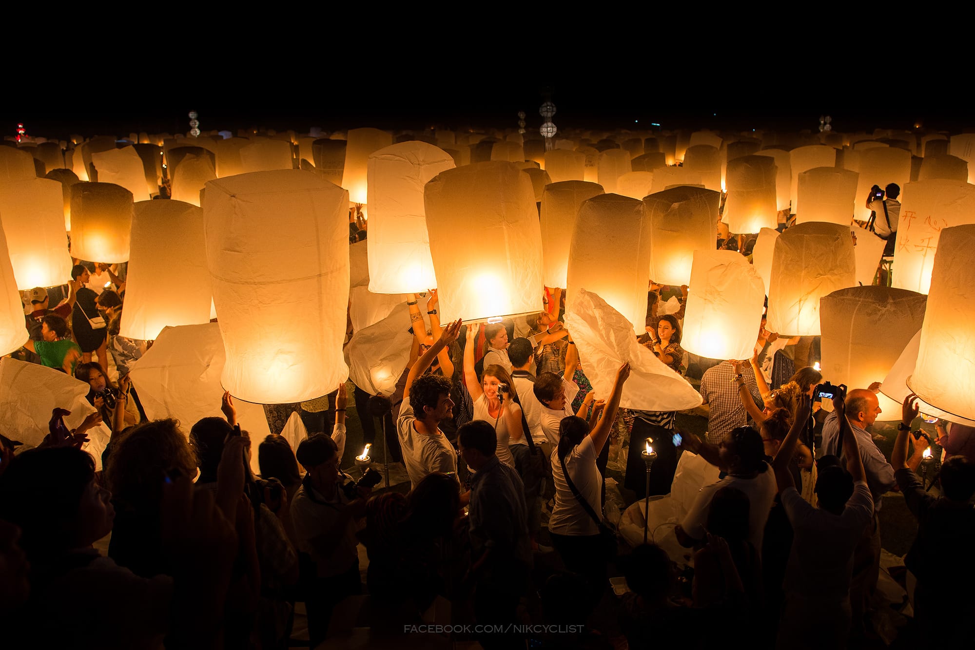 People preparing to launch khom loi sky lanterns at Yi Peng in Chiang Mai