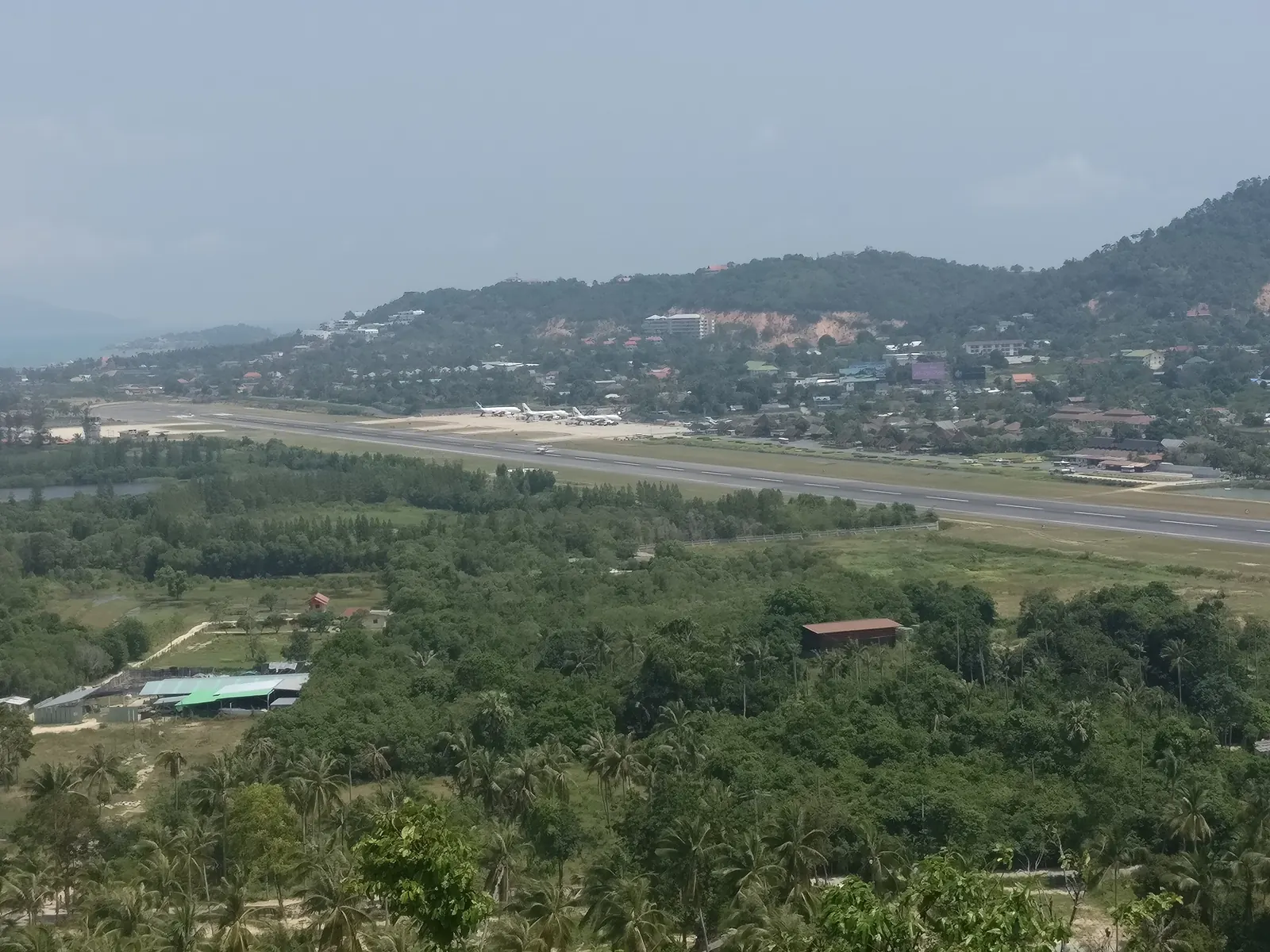Samui Airport seen from above, with the open-air terminal among the palms