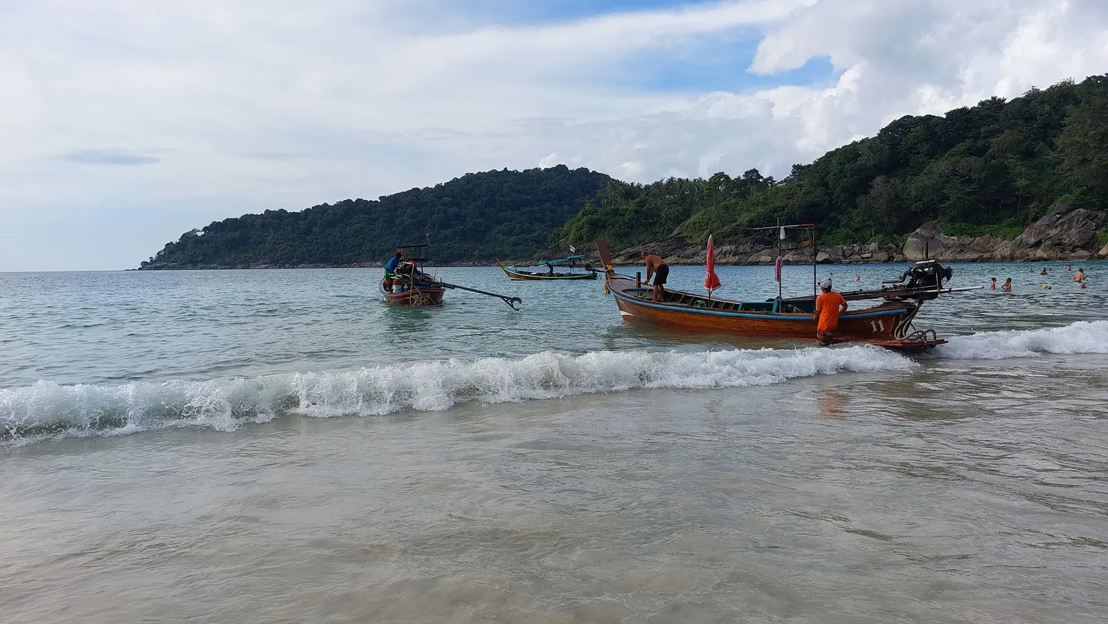 Freedom Beach, Phuket, on a calm day with a longtail boat in the shallows