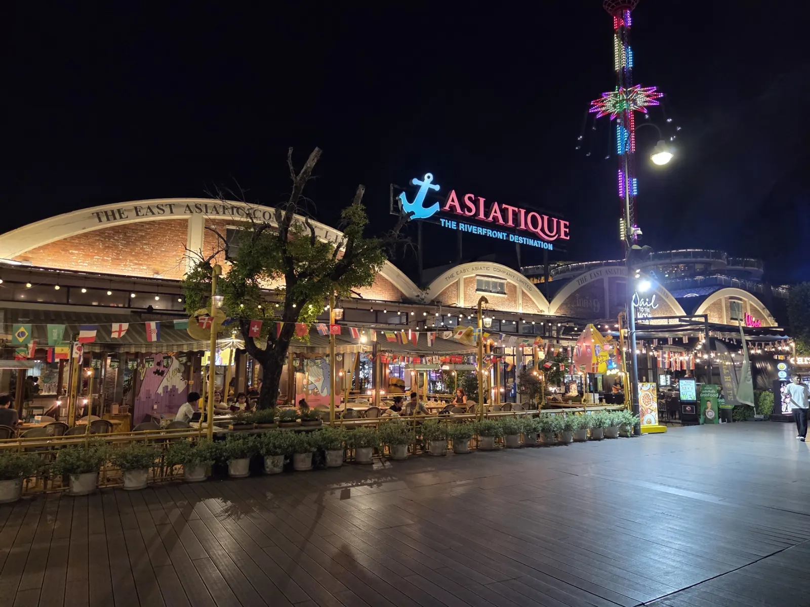 Asiatique The Riverfront and its Ferris wheel lit up at night beside the Chao Phraya river in Bangkok
