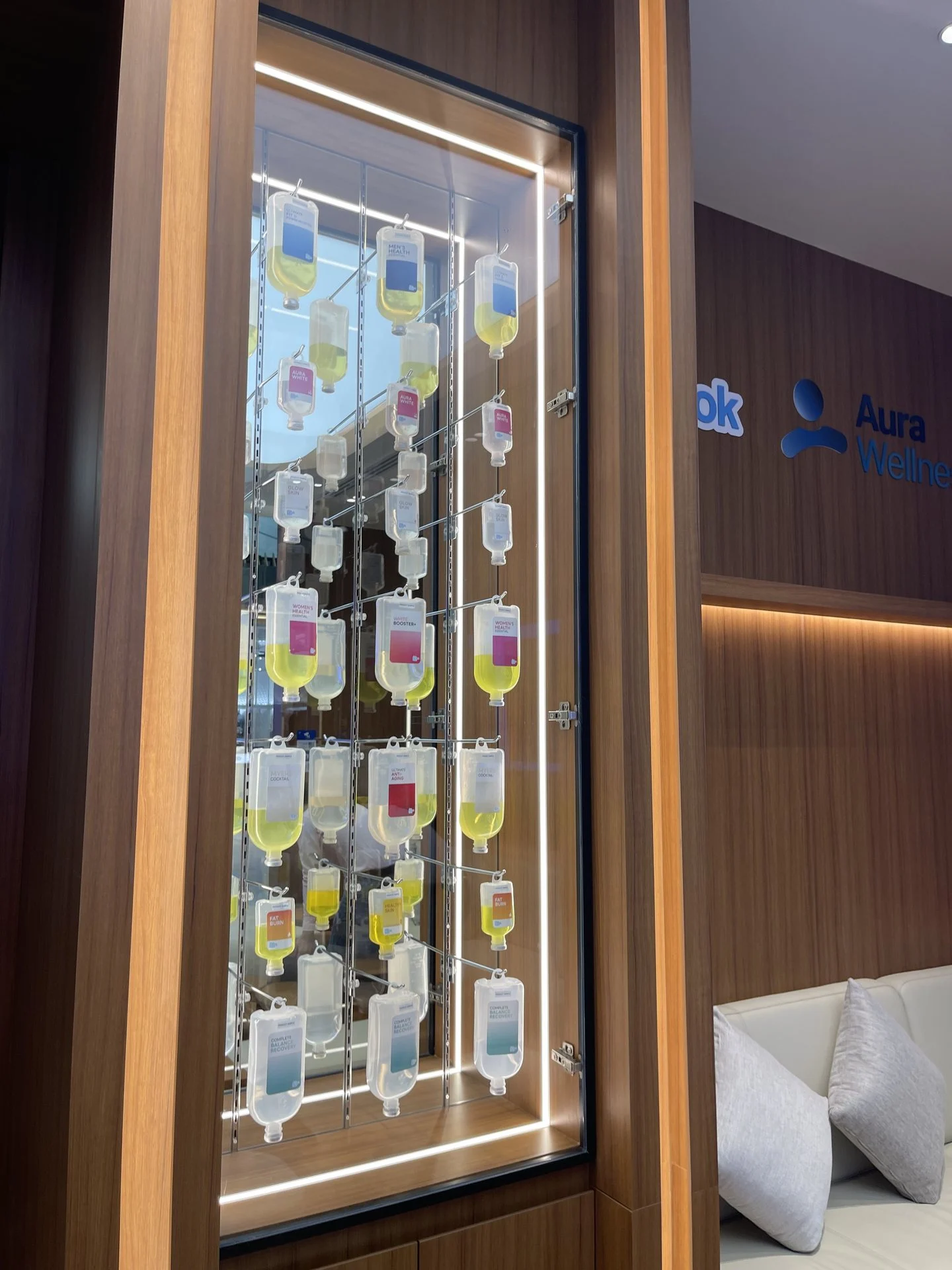 Backlit display wall of IV drip formula bags at Aura Bangkok Clinic Suvarnabhumi Airport branch