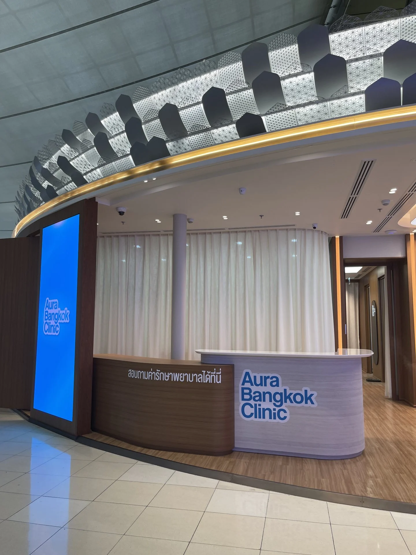 Curved reception counter at the entrance of Aura Bangkok Clinic Suvarnabhumi Airport branch