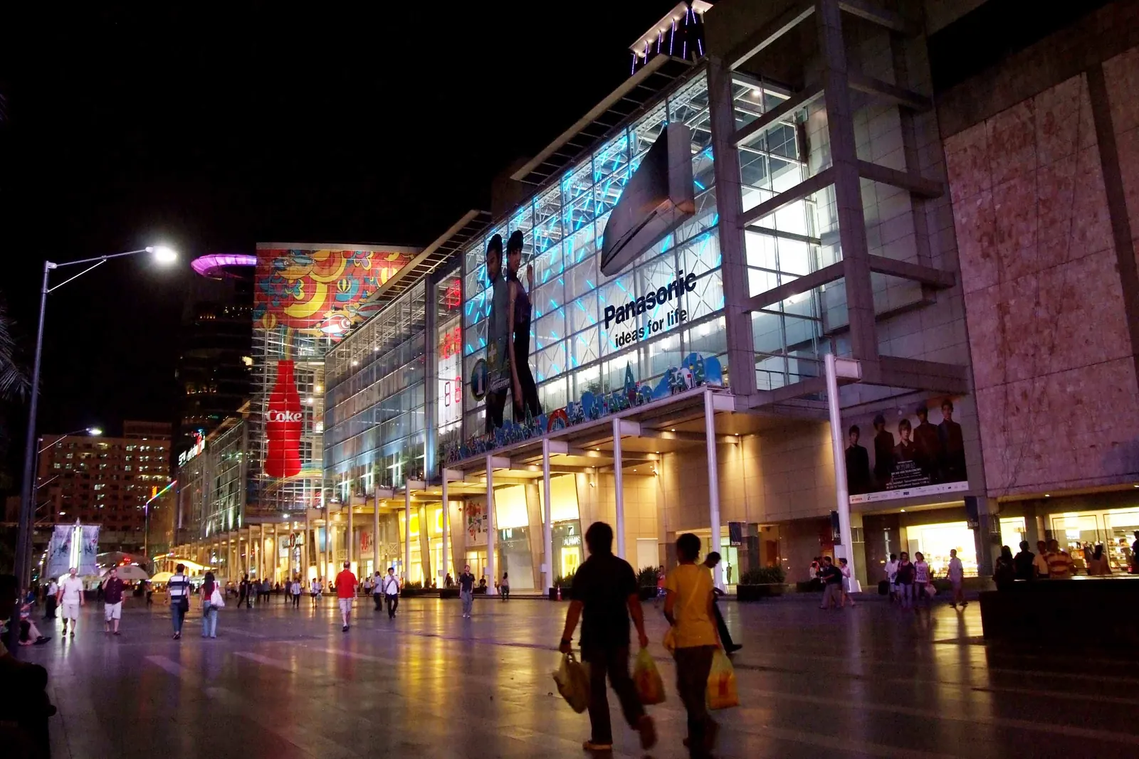 The CentralWorld facade lit at night with people on the square, Bangkok