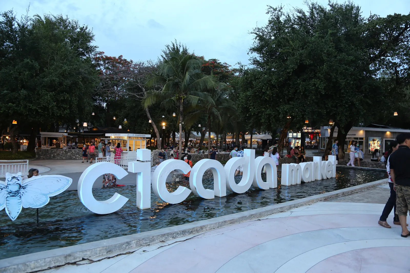 Cicada Market Hua Hin art stalls and open-air stage under casuarina trees at night