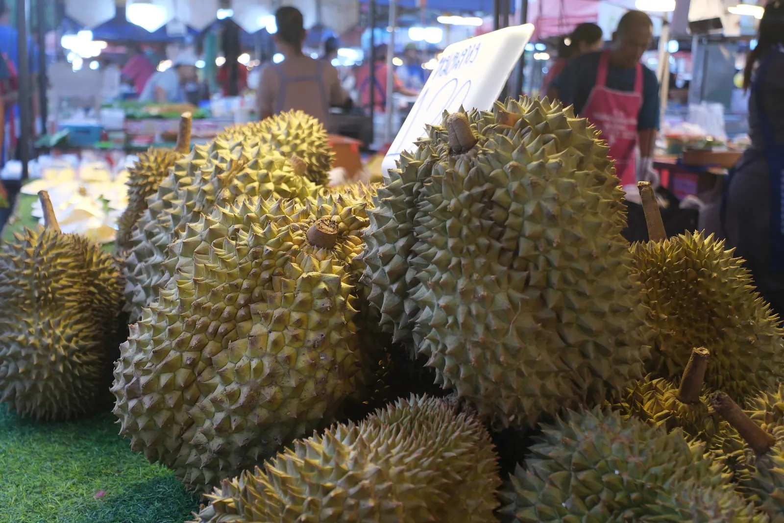 Whole durians piled on a market stall in Thailand