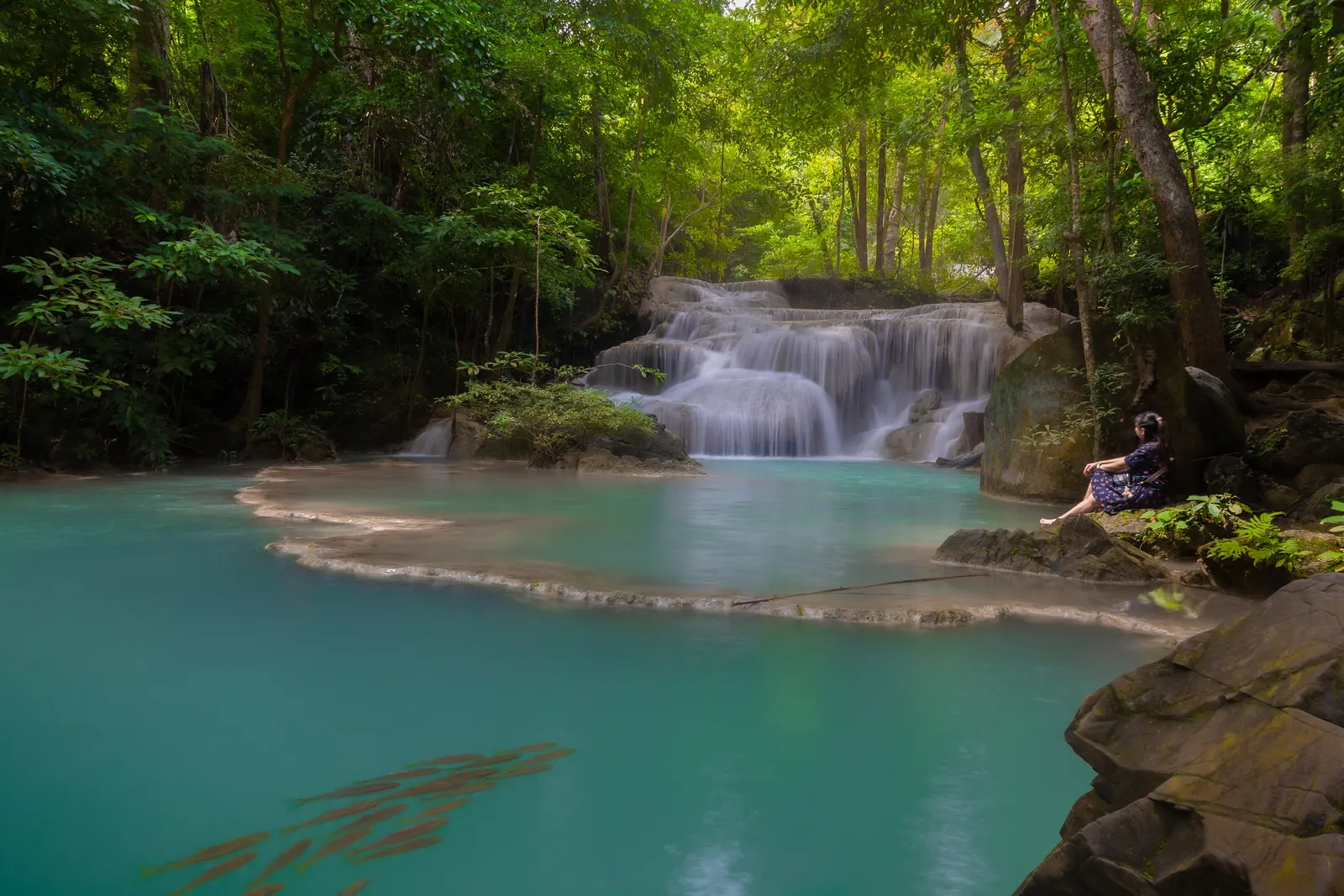 A turquoise pool below one of the limestone tiers of Erawan Falls in Erawan National Park, Kanchanaburi
