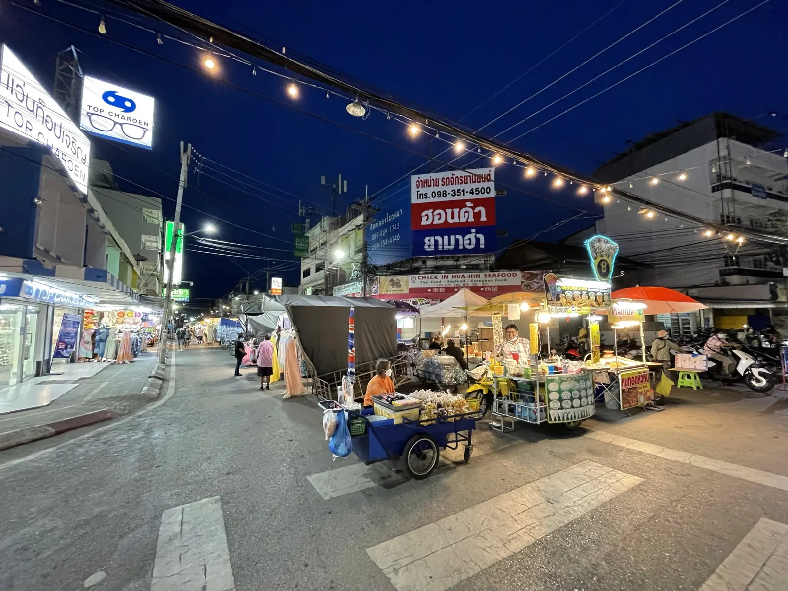 Hua Hin night market on Dechanuchit Road lit up at night with food stalls and crowds