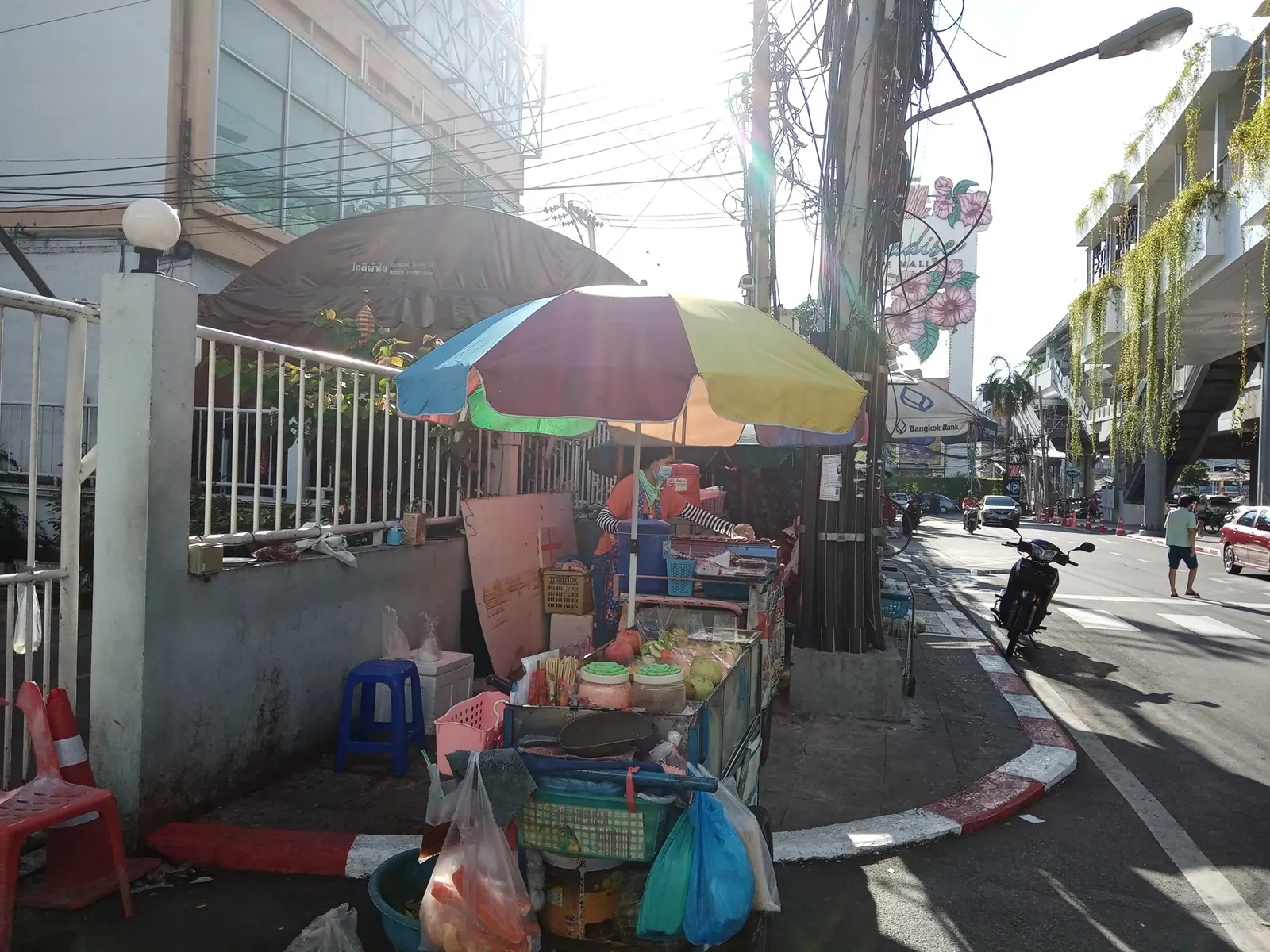 A street fruit cart under an umbrella on a Bangkok pavement near The Mall Bang Khae