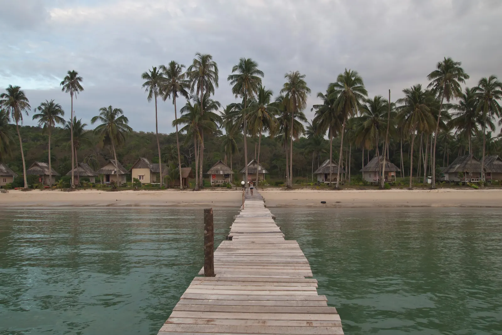 The pier at Bang Bao beach on Koh Kood with coconut palms behind the sand