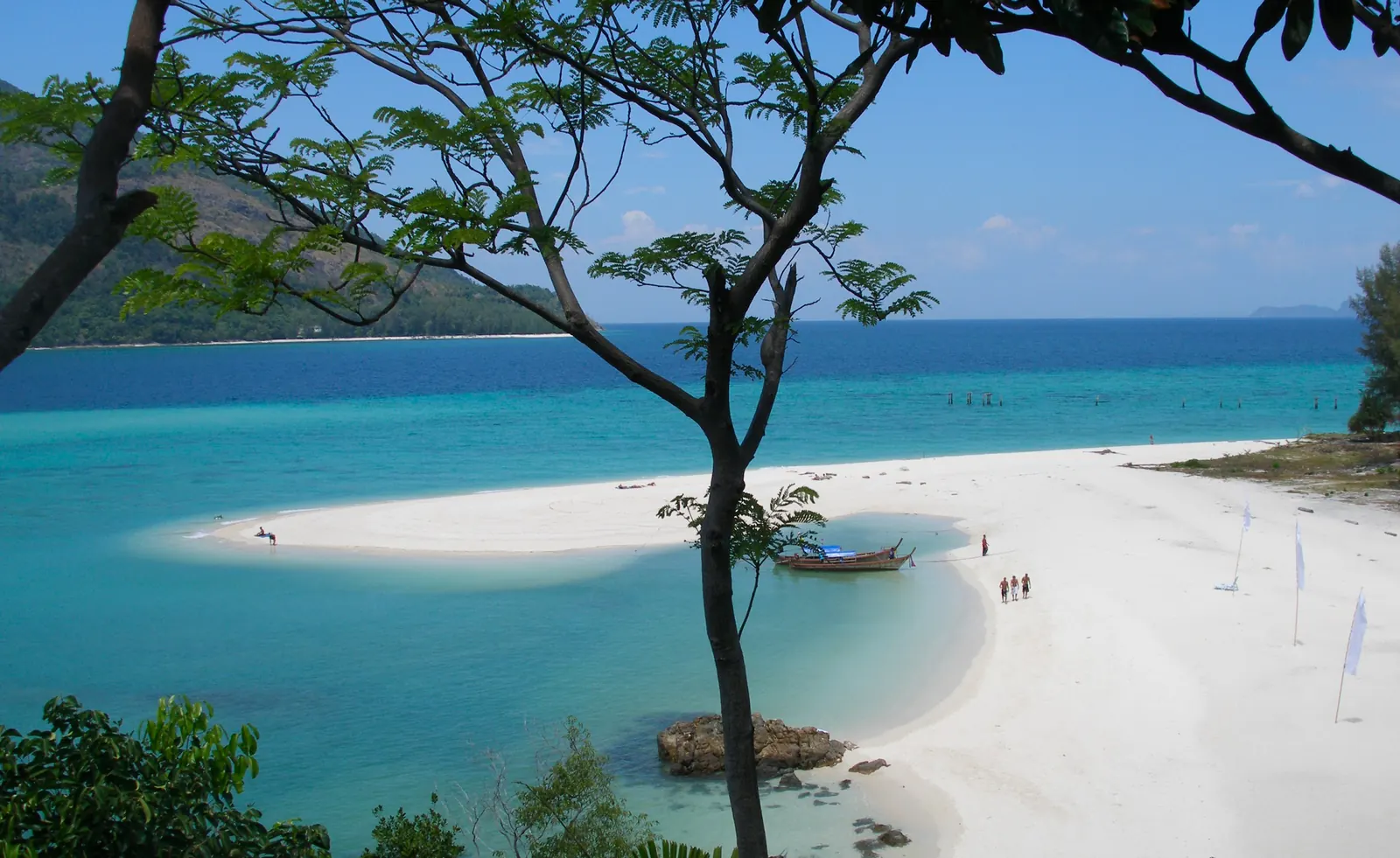 A longtail boat off a white-sand beach on Koh Lipe