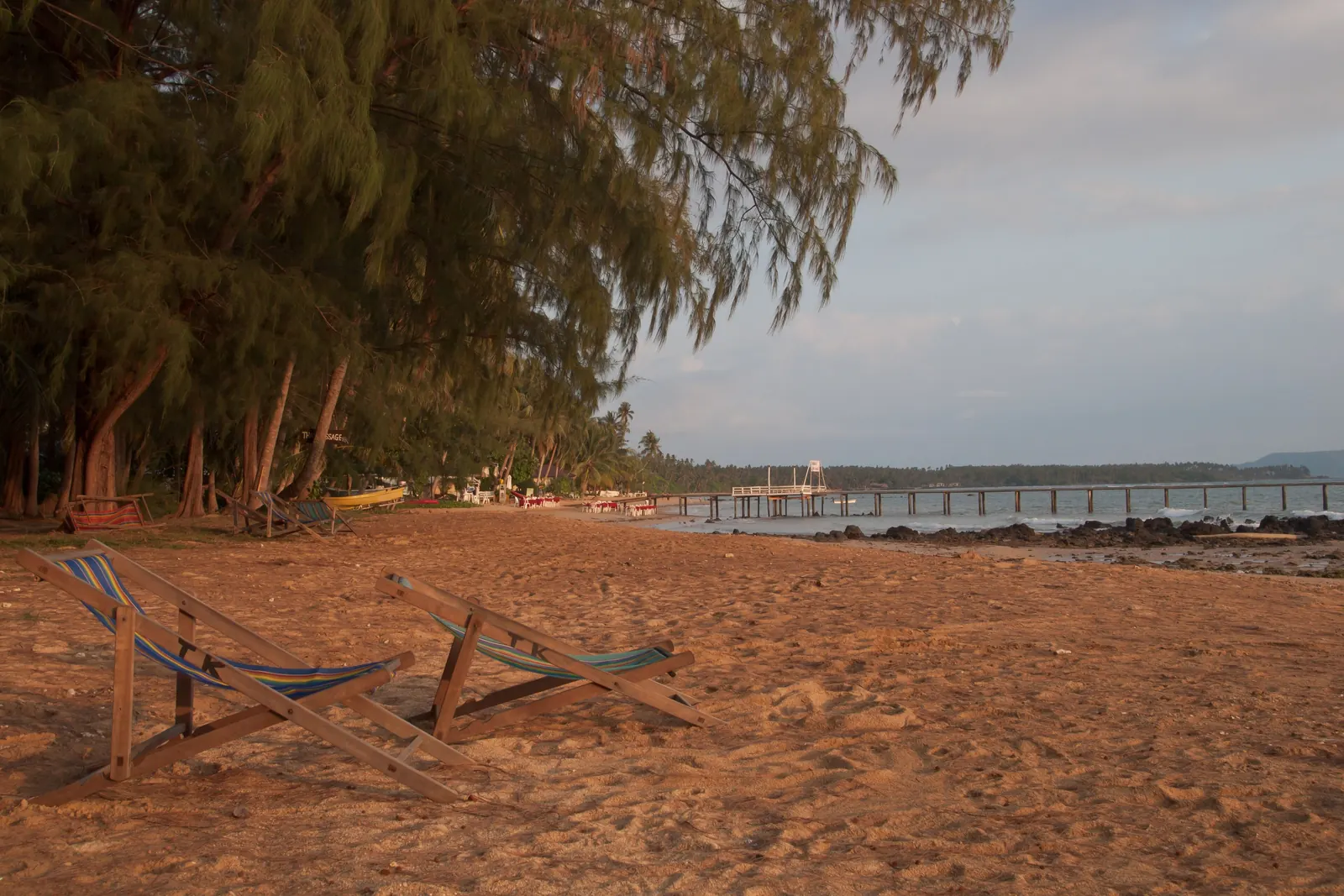 A Koh Mak beach before sunset with calm water and coconut palms