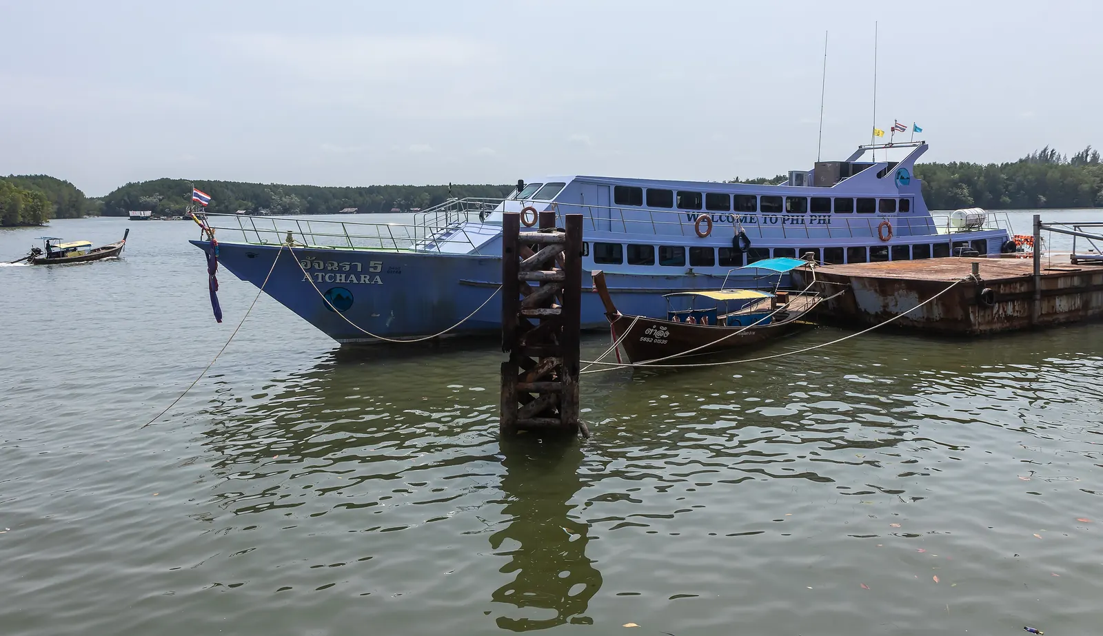 Longtail boats on the Krabi River at Krabi Town with the Khao Khanab Nam limestone peaks behind