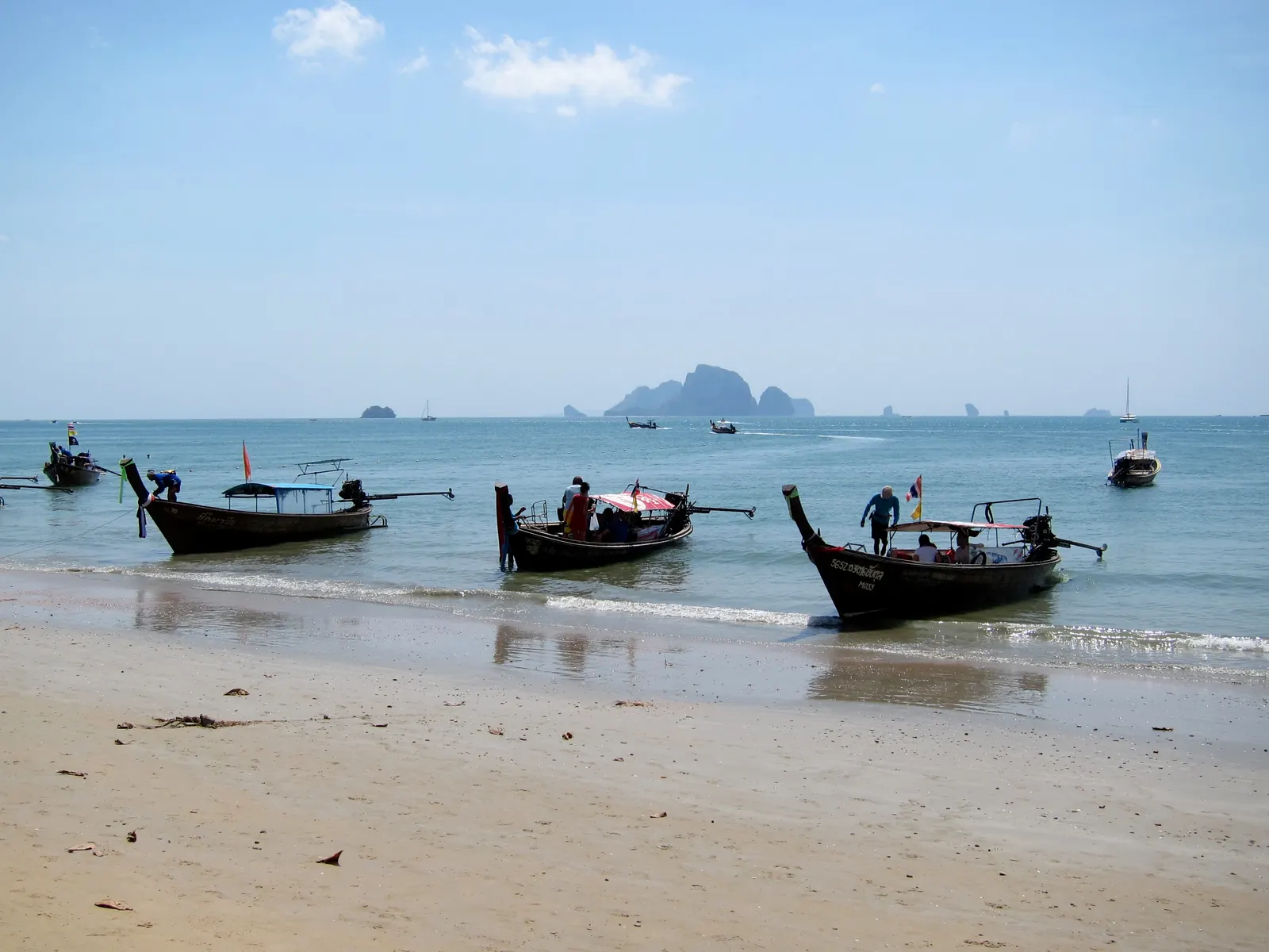 Ao Nang beach in Krabi with longtail boats moored along the sand in the evening