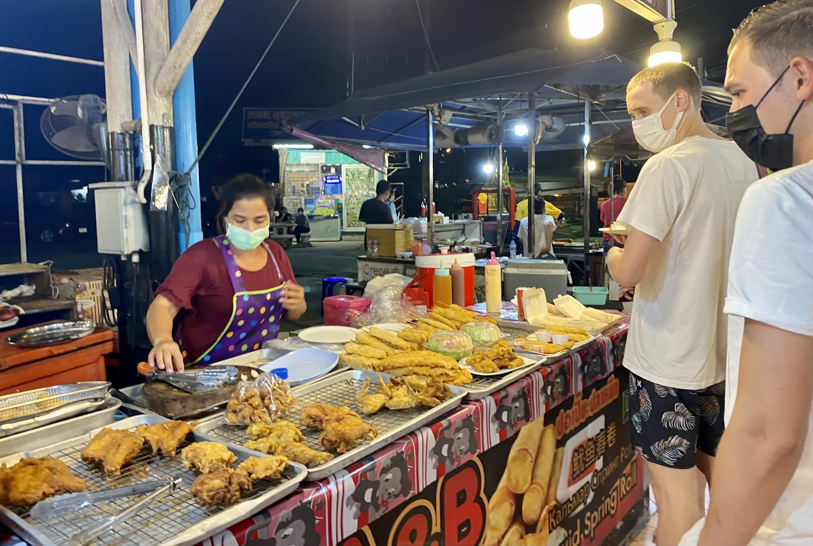 A grilled-food stall with its cook at a Phuket night market, January 2022