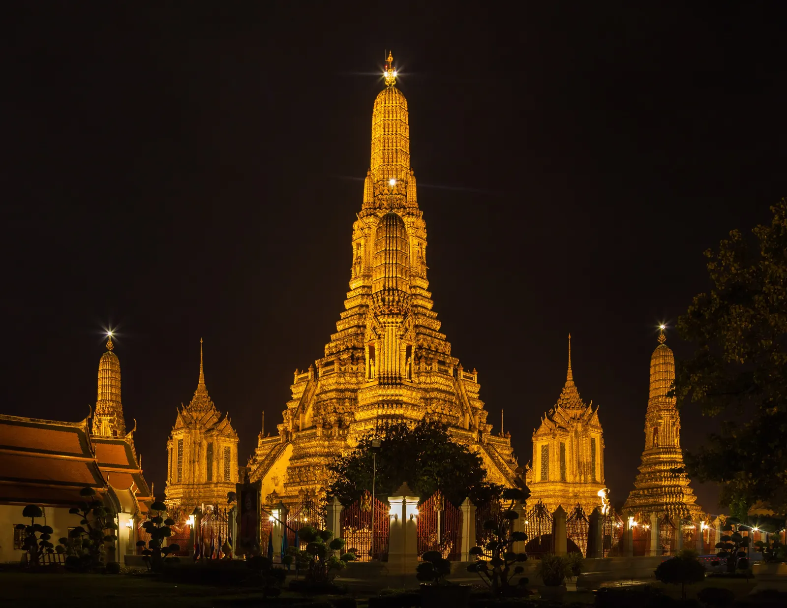 Wat Arun temple lit up at night on the Chao Phraya river, Bangkok