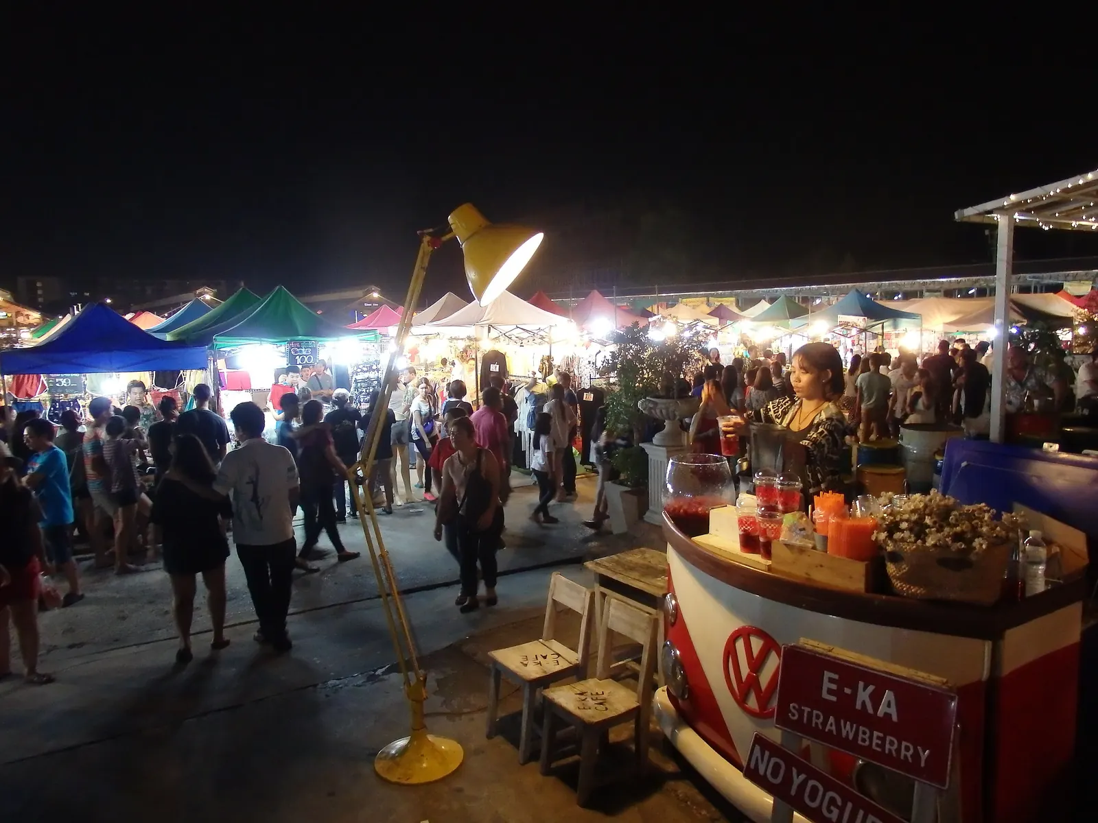 Rows of lit food stalls and crowds at a night market on Ratchadaphisek Road, Bangkok